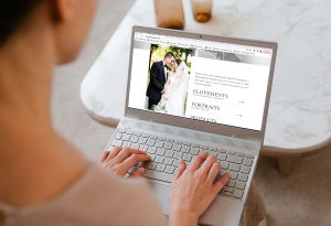 A photographer browsing a wedding photography website on a laptop — a subtle nod to how professionals might fall into the comparison trap by measuring success against curated portfolios.